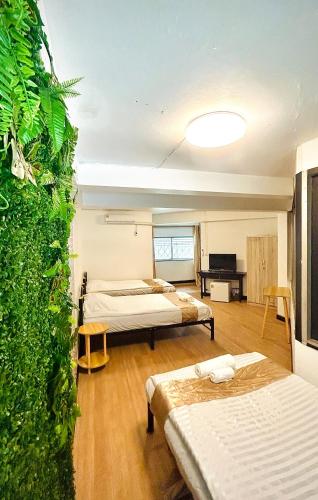 MakkasanにあるCoco House Sukhumvit 1, BTS ploenchitの緑の壁の客室で、ベッド2台が備わります。