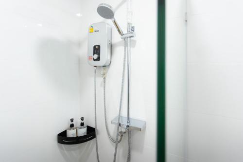une douche dans une salle de bain avec une pomme de douche dans l'établissement Peaceful Townhouse in Sathorn Near Saint Louis BTS, à Yan Nawa