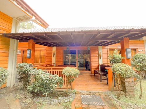 a wooden house with a pergola and a bench at Hortz Hotels And Resorts in Tagaytay