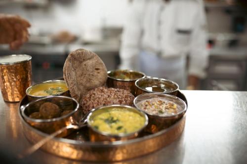 a tray of food on a table in a kitchen at Brij Atmanya Bhowali, Nainital, A Luxury Mountain Escape in Nainital