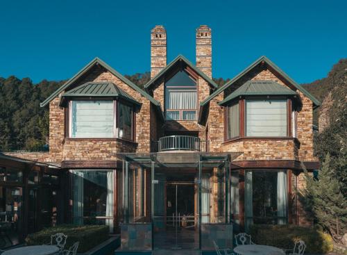 a large brick house with two chimneys at Brij Atmanya Bhowali, Nainital, A Luxury Mountain Escape in Nainital