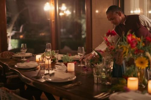 a man sitting at a table with a table centerpiece at Brij Atmanya Bhowali, Nainital, A Luxury Mountain Escape in Nainital