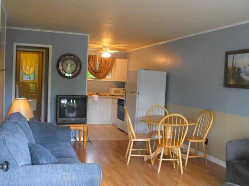 a living room with a blue couch and a table and chairs at The Villas on Lake George in Diamond Point