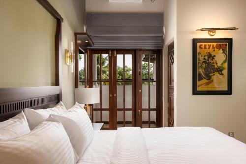 a bedroom with a large white bed with white pillows at Regal Rivera Villa in Negombo