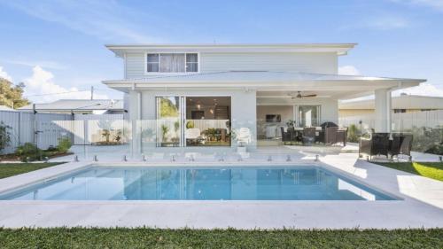 a house with a swimming pool in the yard at Calypso - Pool, Walk To Beach, Sawtell in Sawtell