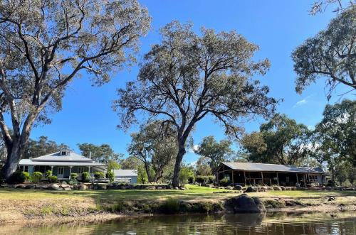 a house next to a river and trees at Diamondvale Estate Stanthorpe in Stanthorpe