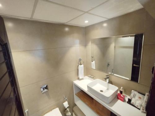 a bathroom with a sink and a mirror at Hotel KK By Spree Rajkot in Rajkot