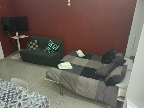 a small bedroom with a bed and a couch at La dimora dalle Mura in Savona