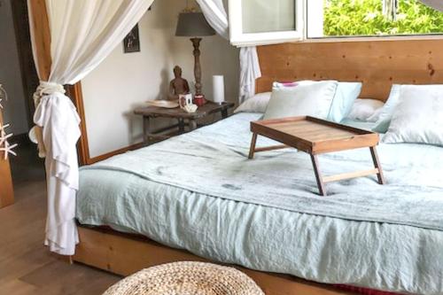 a bedroom with a bed with a table on it at Maison d'exception à Arbonne, piscine privée saisonnière. in Arbonne
