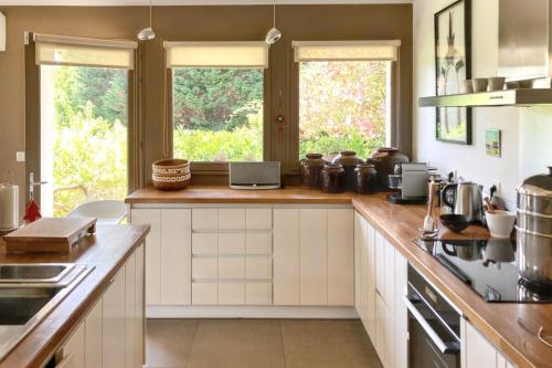 une cuisine avec des armoires blanches et un comptoir dans l'établissement Maison d'exception à Arbonne, piscine privée saisonnière., à Arbonne