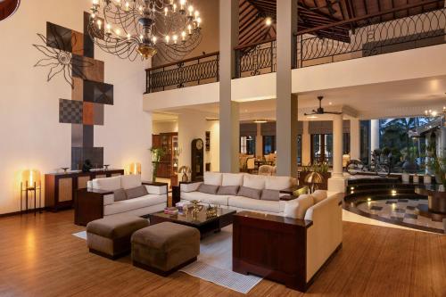 a living room with white furniture and a chandelier at Regal Rivera Villa in Negombo