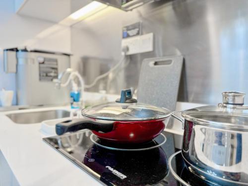 una olla roja en la parte superior de una estufa en la cocina en Georgetown near Gurney and Straits Quay Seaview with Netflix and Washer Dryer, en George Town