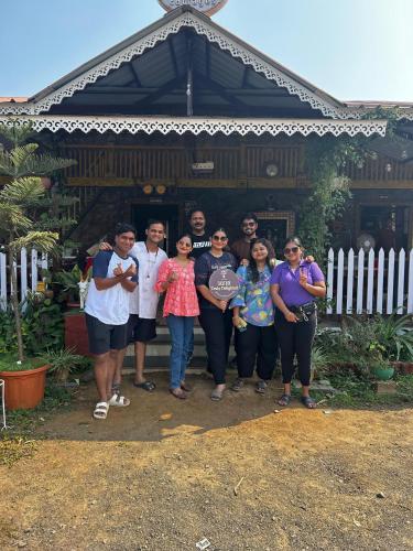 a group of people standing in front of a house at Windchime Cottages in Alibaug