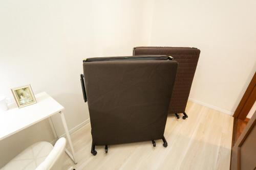 a black suitcase sitting in a room next to a desk at Miraie Yokkaichi Takasagocho in Yokkaichi