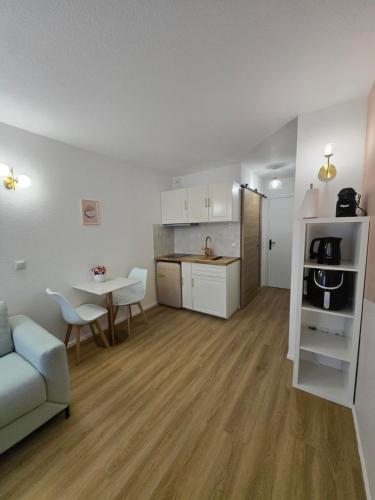 un salon et une cuisine avec un canapé et une table dans l'établissement Le Studio Pastel, à Bussy-Saint-Georges