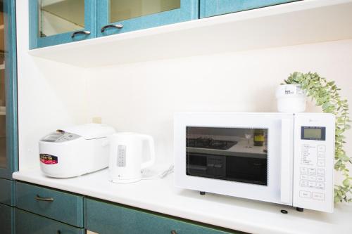 a white microwave oven on a counter in a kitchen at Miraie Yokkaichi Takasagocho in Yokkaichi