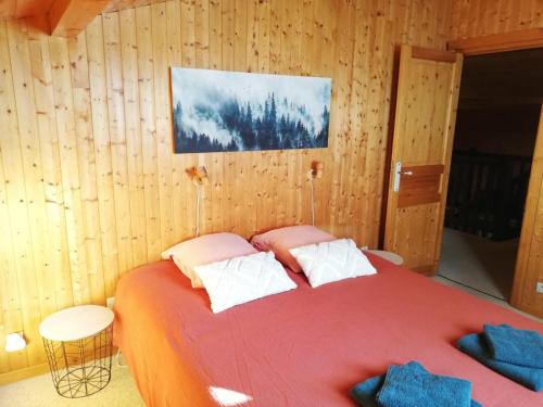 une chambre avec un grand lit dans une pièce en bois dans l'établissement Chalet Paolina proche le Grand Bornand et la Clusaz, à Glières-Val-de-Borne