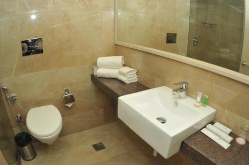 a bathroom with a sink and a toilet and a mirror at Royale Lalit Hotel Jaipur in Jaipur