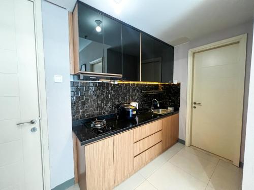 a bathroom with a sink and a mirror at Best Choice and Comfortable Living 2BR at Anderson Supermall Mansion Apartment By Travelio in Surabaya