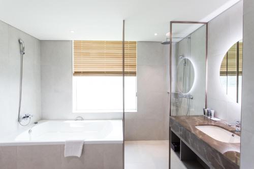 a bathroom with a tub and a sink at Interburgo Hotel Wonju in Wonju