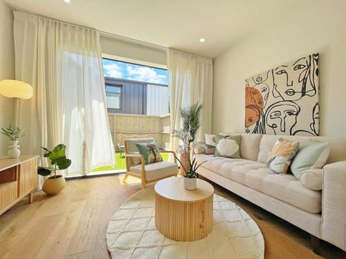 a living room with a couch and a table at City Serenity 2BR Townhouse vs AC Backyard & Parking in Auckland