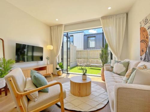 a living room with a couch and a table at City Serenity 2BR Townhouse vs AC Backyard & Parking in Auckland