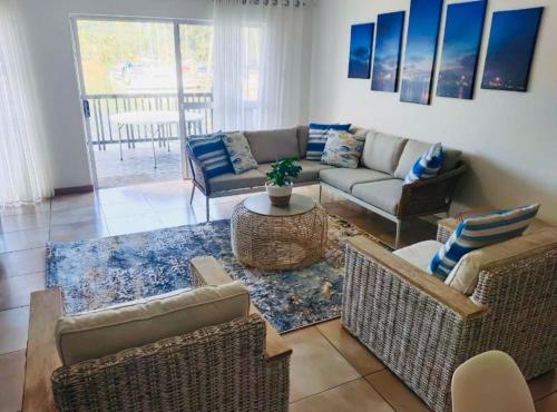 a living room with a couch and chairs and a table at Mzingazi Waterfront Accommodation, On The Bay Waterfront Villa's in Richards Bay