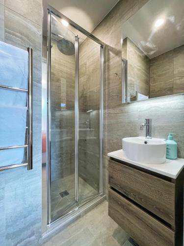 a bathroom with a sink and a shower at City Serenity 2BR Townhouse vs AC Backyard & Parking in Auckland