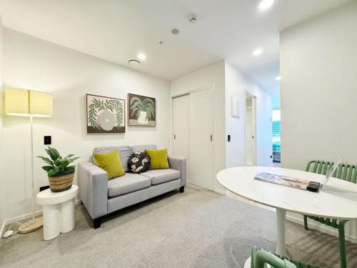 a living room with a couch and a table at Lush City Escape - Fresh 1B Studio Near Skytower Pool Gym SaunaSauna in Auckland