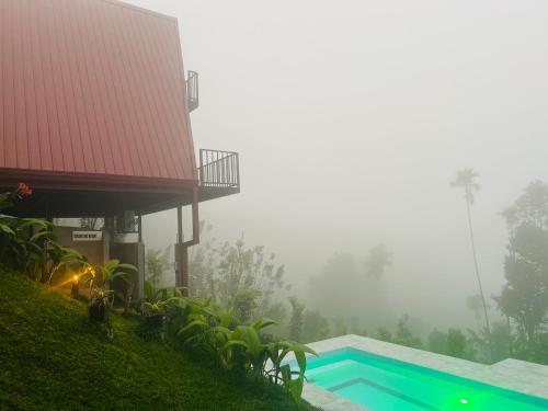 a house in the fog with a swimming pool at Misty Haven A-Frame in Kandy