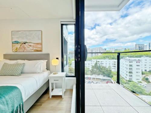 a bedroom with a bed and a large window at Lush City Escape - Fresh 1B Studio Near Skytower Pool Gym SaunaSauna in Auckland