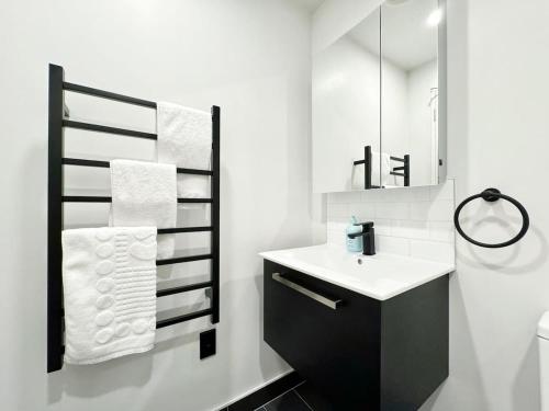 a bathroom with a sink and a mirror at Lush City Escape - Fresh 1B Studio Near Skytower Pool Gym SaunaSauna in Auckland