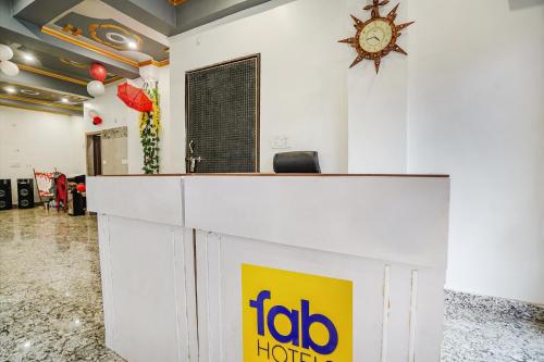 a reception desk with a clock on a wall at FabHotel Raghav Raj Inn in Varanasi