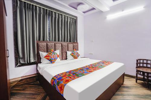 a bedroom with a large white bed with a window at FabHotel Raghav Raj Inn in Varanasi