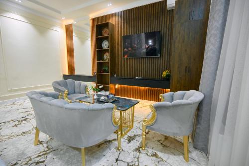 a living room with two chairs and a table and a tv at FIRDAVS HOTEL in Navoi
