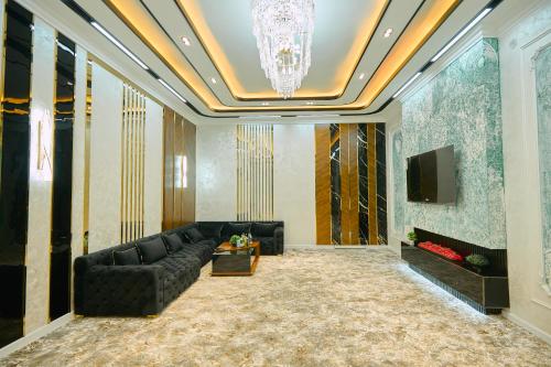 a living room with a black couch and a chandelier at FIRDAVS HOTEL in Navoi