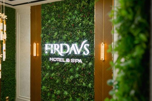 a green wall with a sign that reads fridays hotel and spa at FIRDAVS HOTEL in Navoi