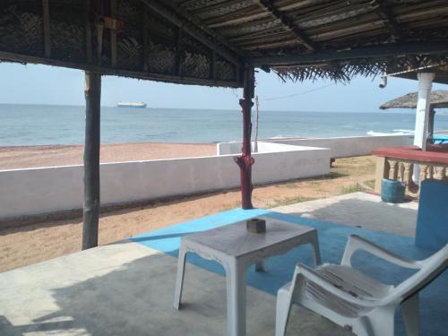 a table and two chairs on a patio near the beach at Happy Beach Cabana in Hambantota