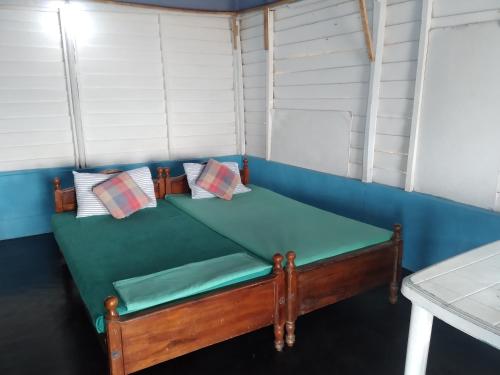 Habitación pequeña con sofá azul y almohadas en Happy Beach Cabana, en Hambantota