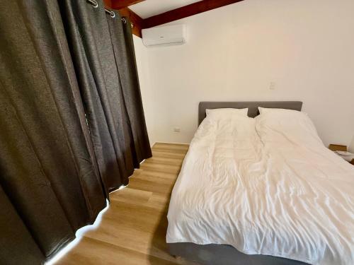 a bedroom with a bed and a black curtain at Comfy Logan - Shared bathrooms - Individual Room with a Queenbed- WiFi AC Netflix in Tanah Merah