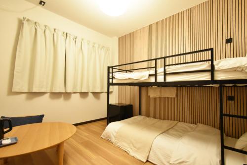 a room with two bunk beds and a table at 民泊富士なんば MinpakuFujiNamba in Osaka