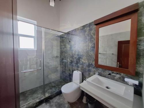 a bathroom with a toilet and a sink and a shower at Luxury Villa in Colombo in Rajagiriya