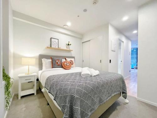 a bedroom with a large bed and a lamp on a table at Serene Cityscape 1B Apt Near Skytower vs Gym Pool Sauna in Auckland