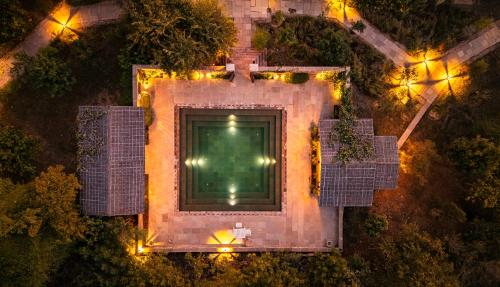an overhead view of a pool at night with lights at The Beehad Sariska in Tehla