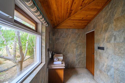a room with a window and a wooden ceiling at The Beehad Sariska in Tehla