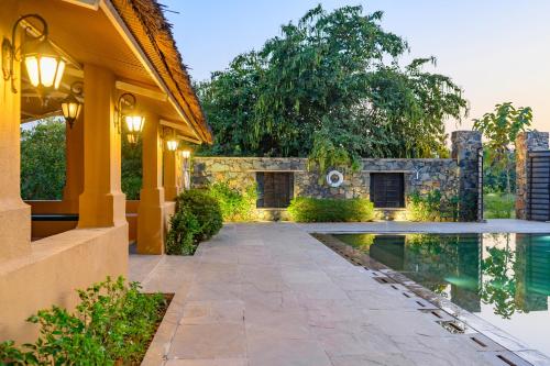 a house with a swimming pool next to a building at The Beehad Sariska in Tehla