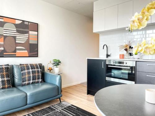 a living room with a couch and a table in a kitchen at Perfect Central Living AC 1 Bed Vs Pool Gym Sauna Near Skytower in Auckland