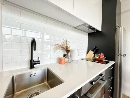 a kitchen with a sink and a counter top at Perfect Central Living AC 1 Bed Vs Pool Gym Sauna Near Skytower in Auckland