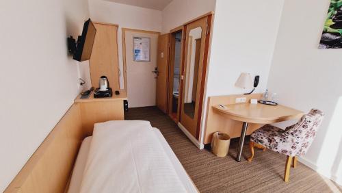 a hotel room with a bed and a desk at Hotel Garni Superior in Metzingen