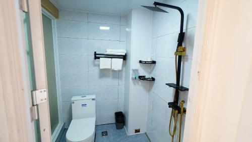 a bathroom with a white toilet and a shower at Yibuxuan Boutique Hotel Yangshuo in Yangshuo